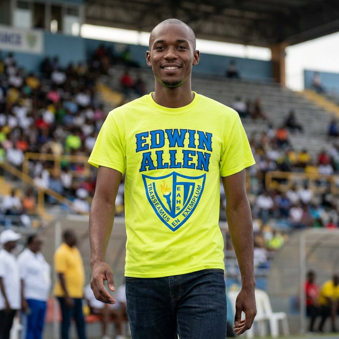 Man wearing a bright yellow 'Edwin Allen' t-shirt in an outdoor stadium setting. EAHS Men's Athletics Performance Tee – Front Logo & Back
