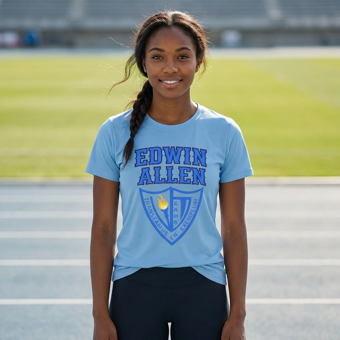 Person wearing a blue 'Edwin Allen' t-shirt on a track field EAHS Women’s Competition Performance Tee – Front Logo